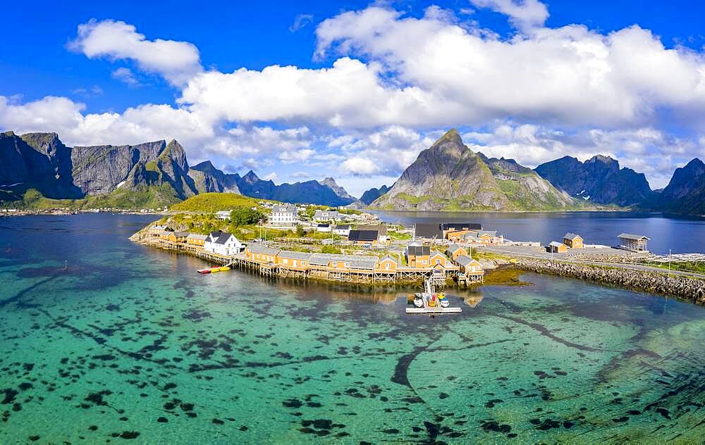 Rorbuer cabins by the fjord with Bergen in the background, fishing village Sakrisoy, Sakrisoy, Reine, Lofoten, Norway, Europe