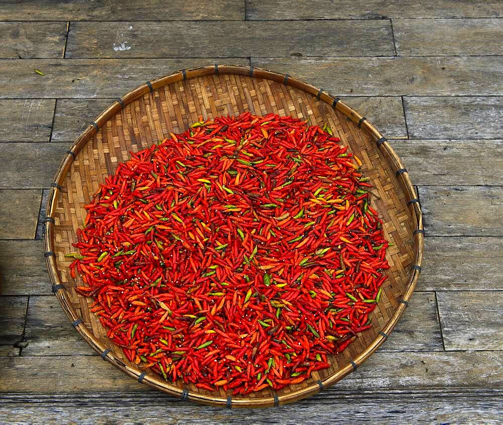 Drying red chillies in a bowl, Luang Prabang, Laos, Asia