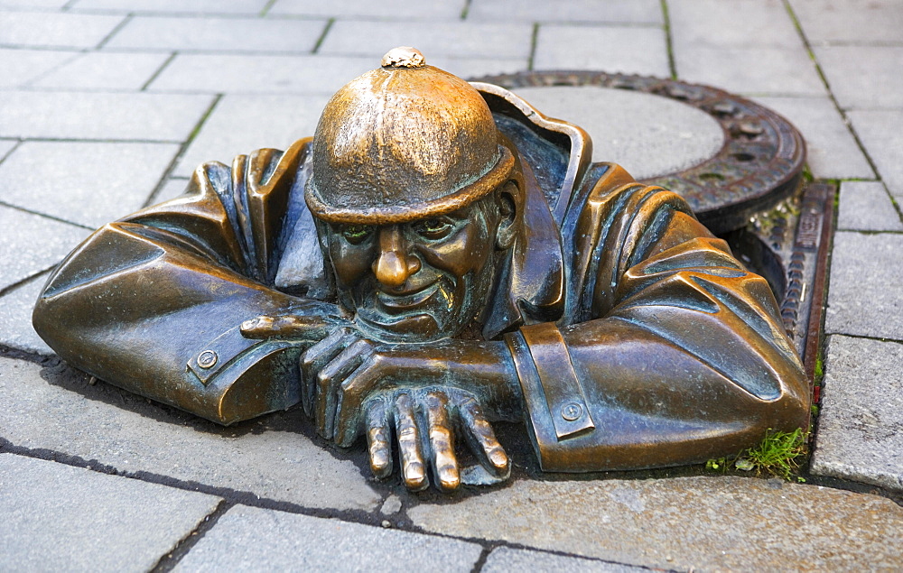 Bronze sculpture The Gaffer in the pedestrian zone, male figure looking out of manhole, Bratislava, Slovakia, Europe