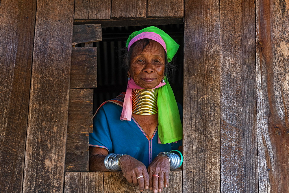 Padaung, giraffe, woman standing in a window frame of her house, Panpet, Loikaw area, Kayah state, Myanmar, Asia