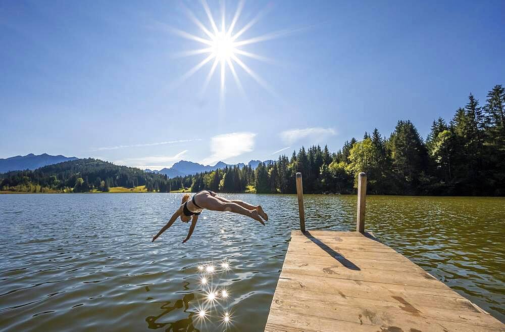 Young woman taking a header into a lake, Geroldsee, Mittenwald, Karwendel, Bavaria, Germany, Europe