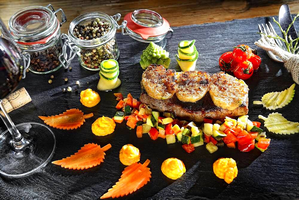 Rump steak with crust and vegetables, served on a slate plate