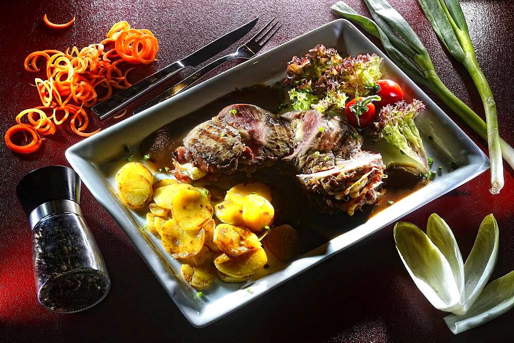 Steak prepared medium roasted cut with fried potatoes and salad