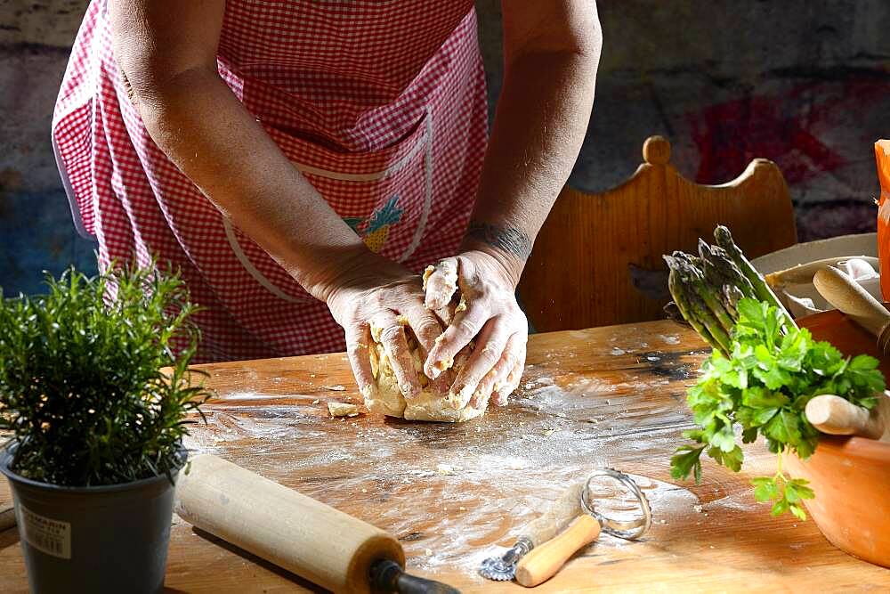 Cook kneading pasta dough for pasta on wooden table, Germany, Europe