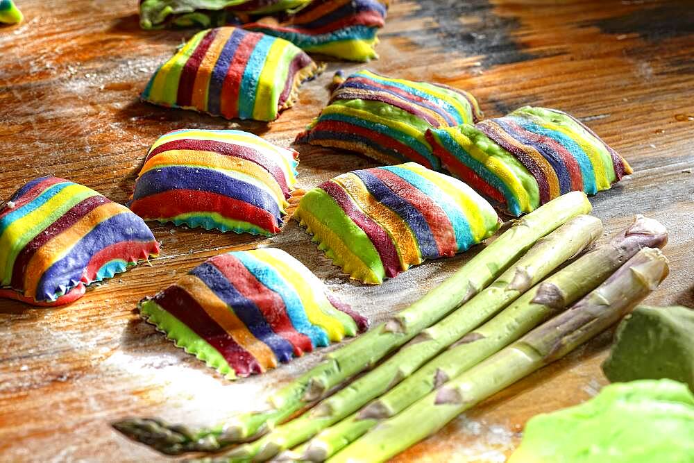 Homemade colorful ravioli on floured wooden table, Germany, Europe