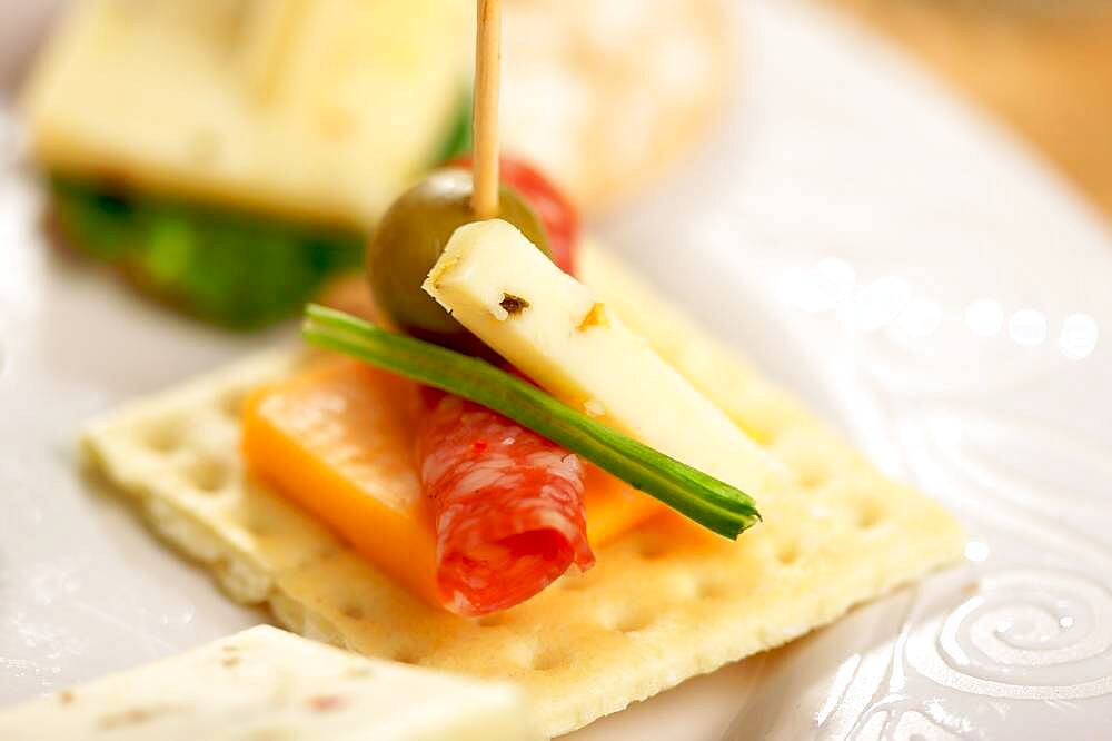 Cracker appetizers with cheese, olive and pepperoni