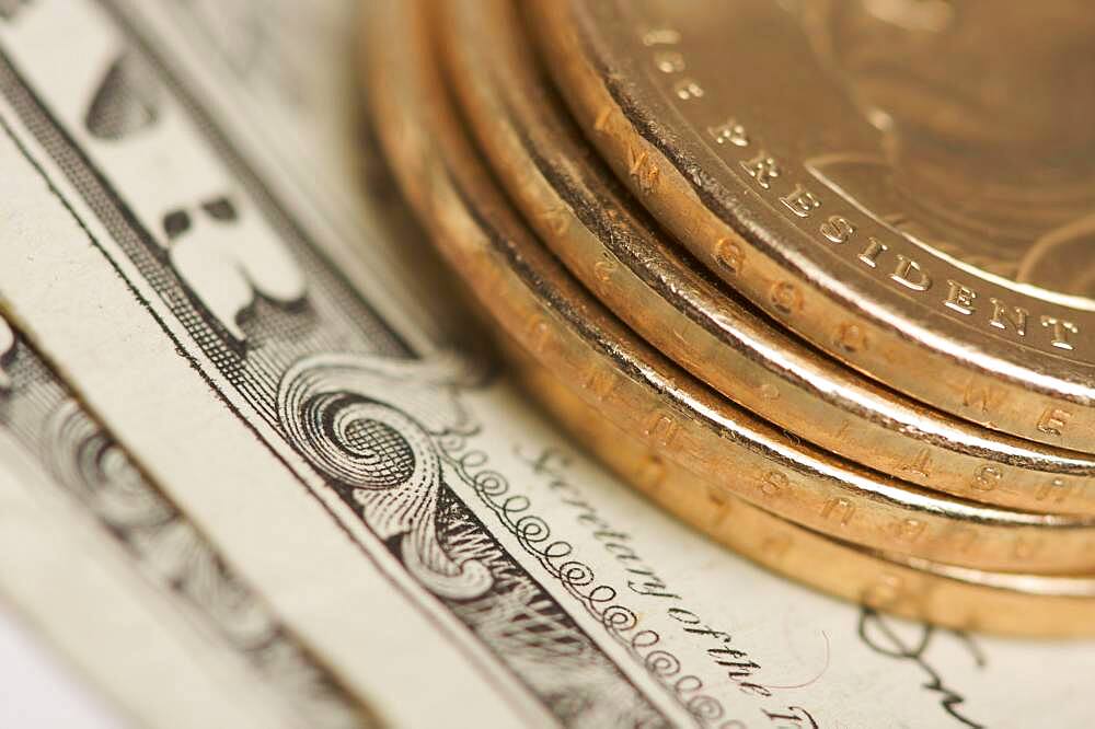 Abstract of the new U.S. dollar coin on dollar bills with narrow depth of field