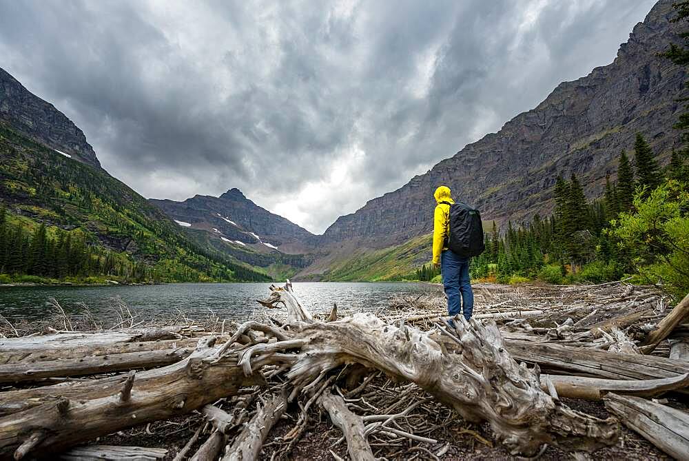 Hikers at Upper Two Medicine Lake, mountain peak Lone Walker Mountain in the back, dramatic clouds, Glacier National Park, Montana, USA, North America