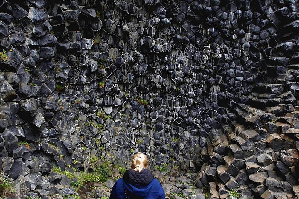 Woman in front of column basalt, Echo Rock Hljooaklettar, Vestudalur, North Iceland, Iceland, Europe