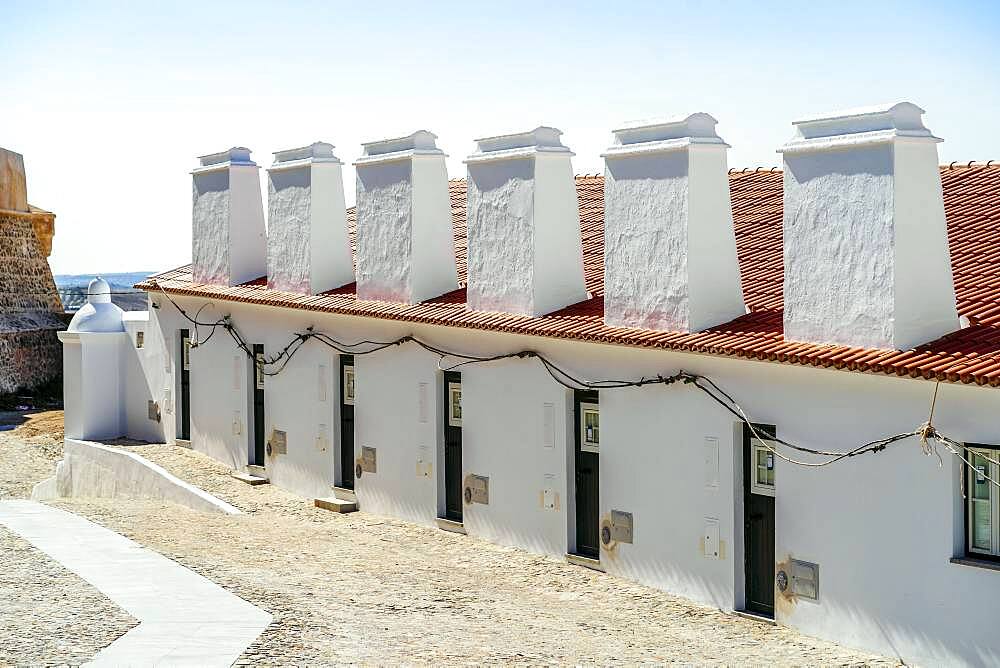 Traditional residential terraced houses with huge chimneys next to castle in Campo Maior, Alentejo, Portugal, Europe