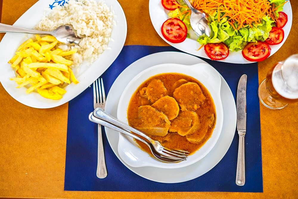 Traditional food from Alentejo, cow's tongue in a sauce served with salad, rice and french fries, Portugal, Europe