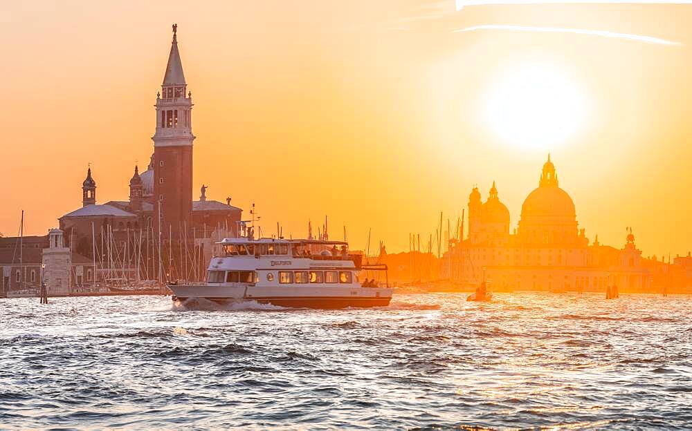 Vaporetto, water bus driving on the lagoon of Venice, evening mood, island Isola di San Giorgio Maggiore with church San Giorgio Maggiore, Basilica Santa Maria della Salute, Venice, Veneto, Italy, Europe