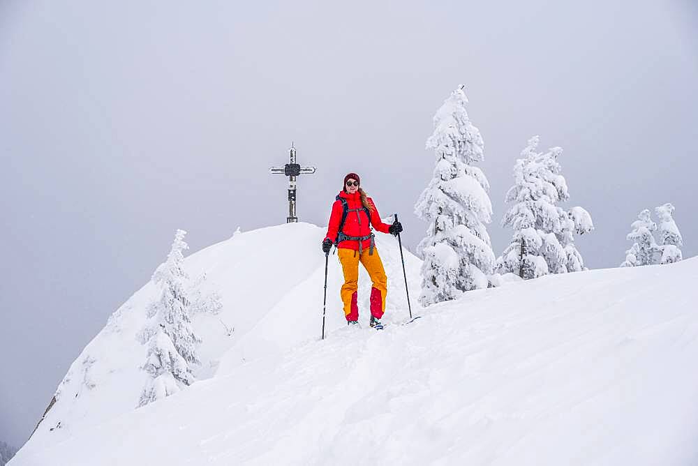 Young woman on ski tour, ski tourers, summit of Rauhkopf in winter, Mangfall mountains, Bavarian Prealps, Upper Bavaria, Bavaria, Germany, Europe