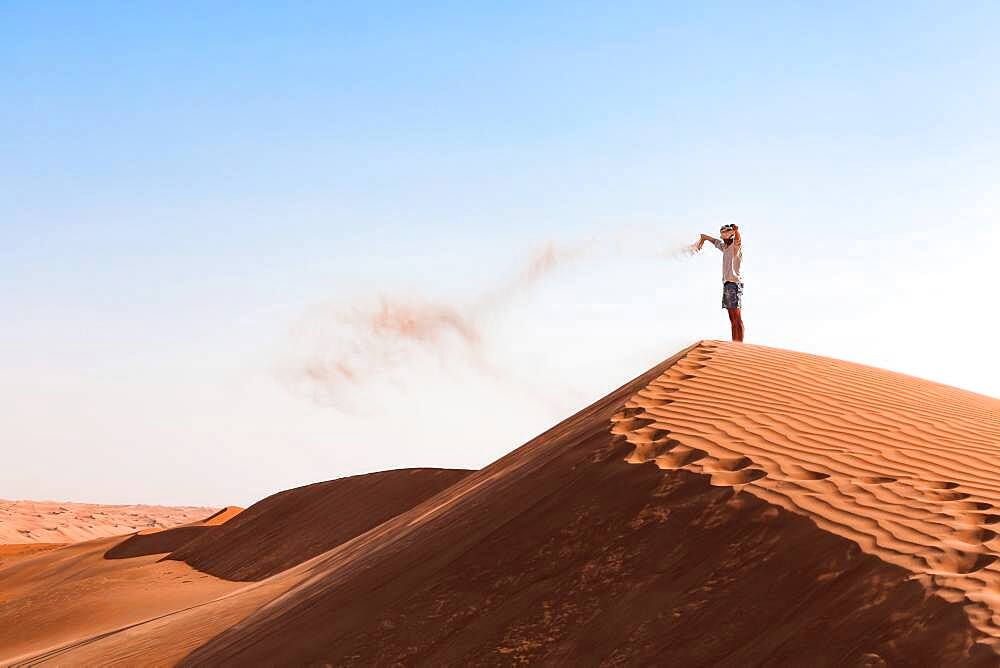 Guy playing with sand in the desert, Wahiba Sands, Sultanate Of Oman