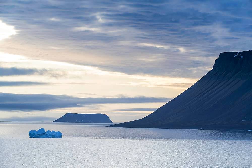 Backlight of flat table mountains covered with ice, Franz Josef Land archipelago, Russia, Europe