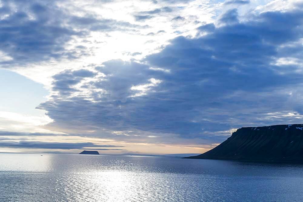 Backlight of flat table mountains covered with ice, Franz Josef Land archipelago, Russia, Europe