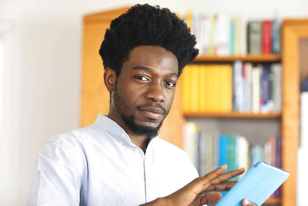 Student with Afro look learning in library, Freiburg, Baden-Wuerttemberg, Germany, Europe