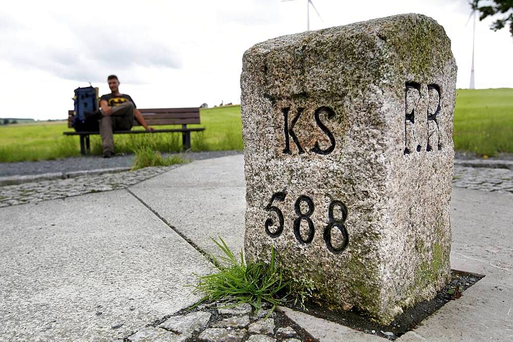 Three Free States Stone, border stone, hiker with backpack sitting on bench, Green Belt, Kolonnenweg, border path, inner German border, hiking trail, Bavaria, Saxony, Thuringia, Germany, Europe