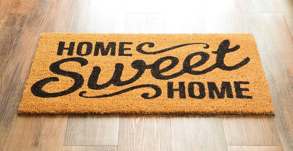 Home sweet home welcome mat on wood floor