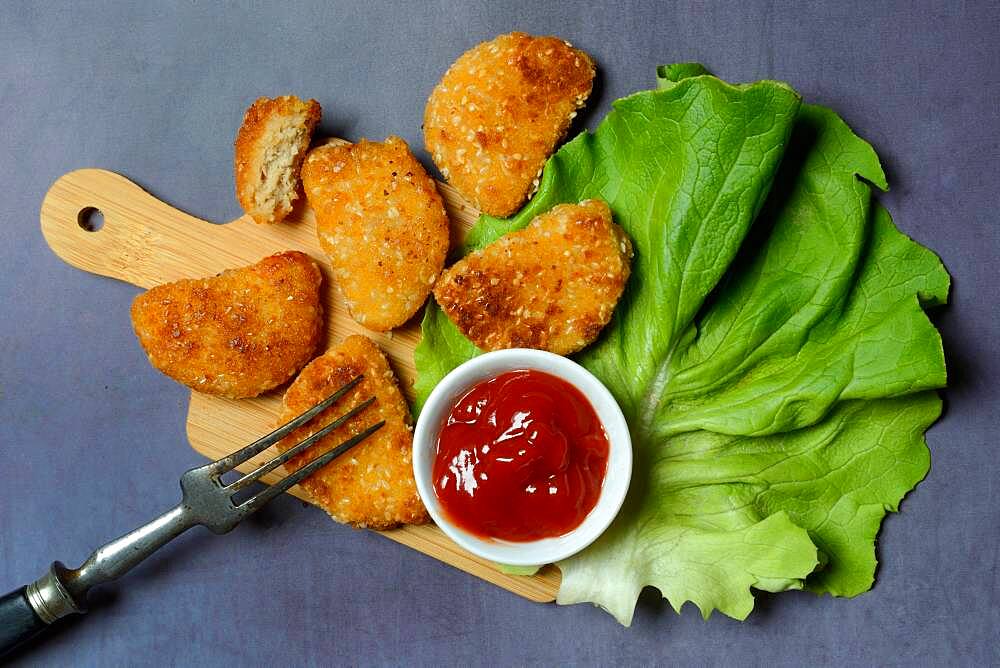 Meat substitute on wooden board and tray with ketchup, imitation meat, Germany, Europe