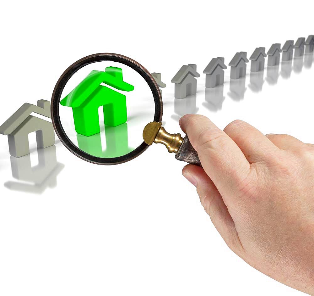 Hand holding magnifying glass up to green house in row of houses on white