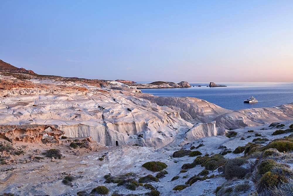 Boat in front of Sarakiniko at sunrise, Milos, Cyclades, Greece, Europe