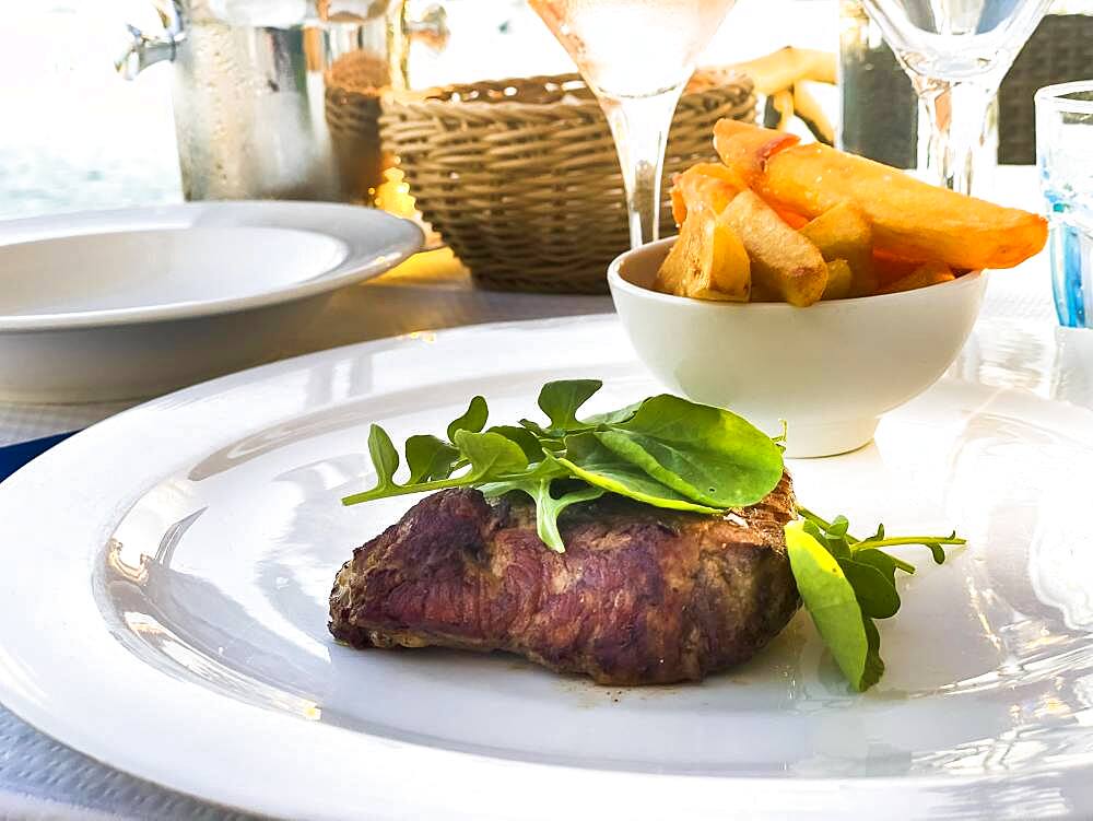 Grilled fillet steak in the evening sun by the sea, Port de Andratx, Majorca, Spain, Europe