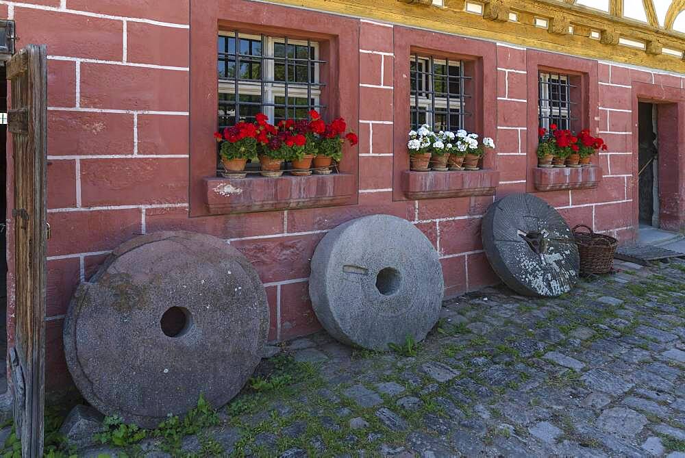 Old millstones in front of the flour mill, built 1575, extended 1601, Franconian Open Air Museum, Bad Windsheim, Middle Franconia, Bavaria, Germany, Europe