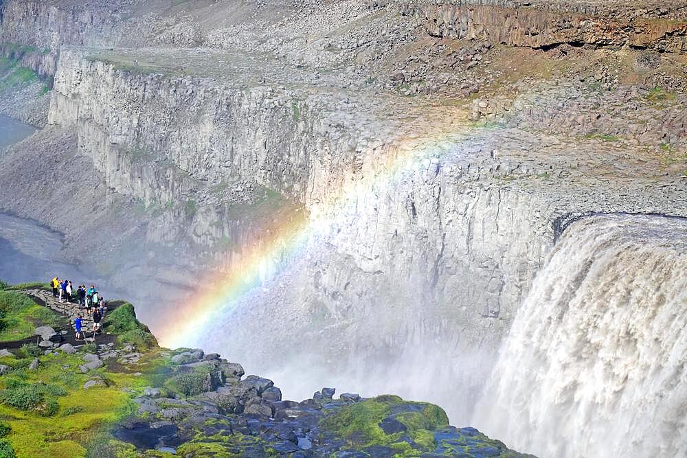 Rainbow in front of waterfall, people on the left, stone desert in the background, Dettifoss, Joekulsa a Fjoellum, Iceland, Europe