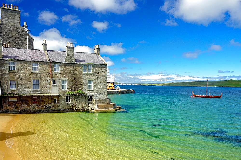 Quiet bay with crystal clear water, harbour, stone house and Viking ship, Lerwick, Shetland Islands, Scotland, United Kingdom, Europe