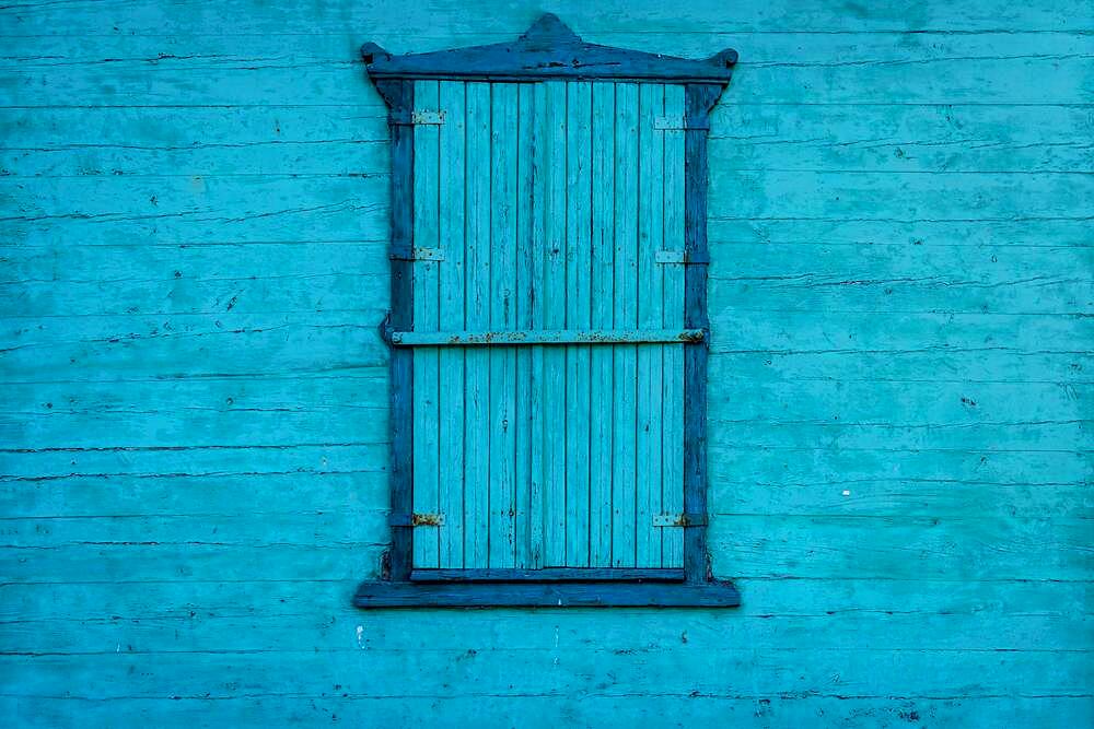 Blue shutters. Wooden wall painted with blue paint. Poland