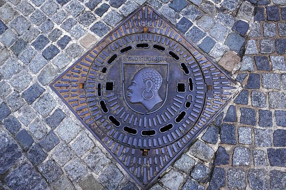 The patron saint of Coburg, the Coburg Moor on a manhole cover, Coburg, Upper Franconia, Germany, Europe