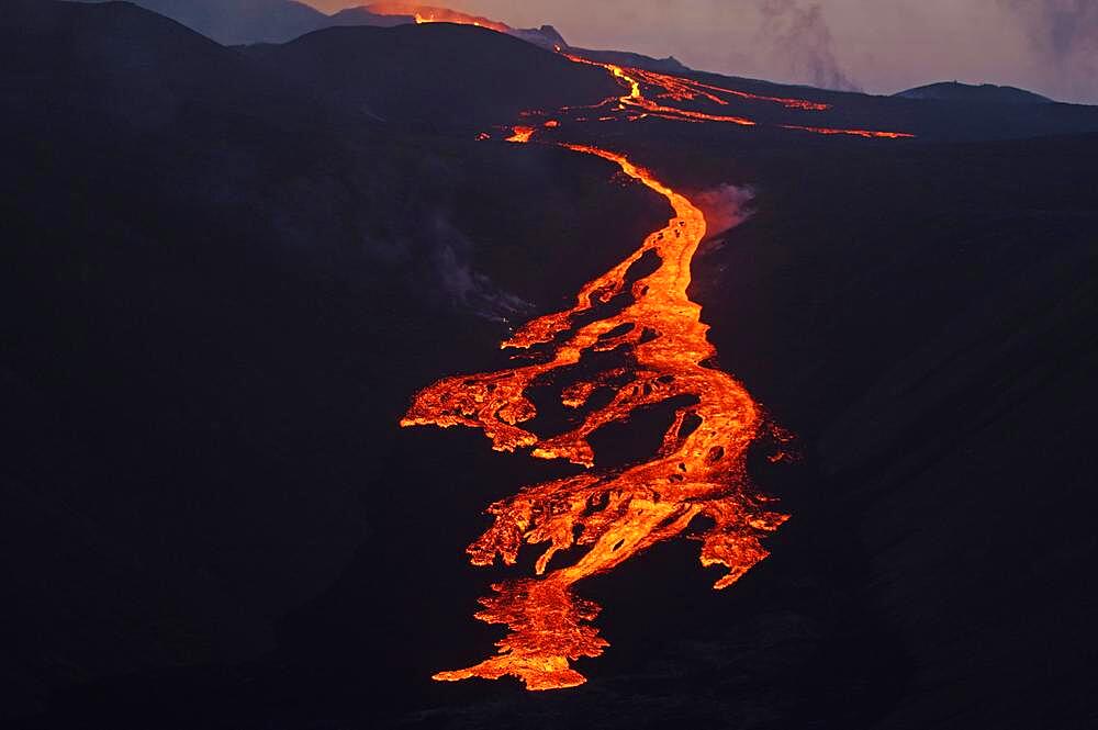 Glowing lava flows partly down mountainside, night shot, Fagradalsfjall, Reykjanes, Grindavik, Sudurnes, Iceland, Europe