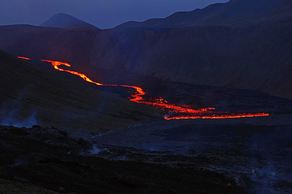 Glowing lava flows partly down mountainside, night shot, Fagradalsfjall, Reykjanes, Grindavik, Sudurnes, Iceland, Europe