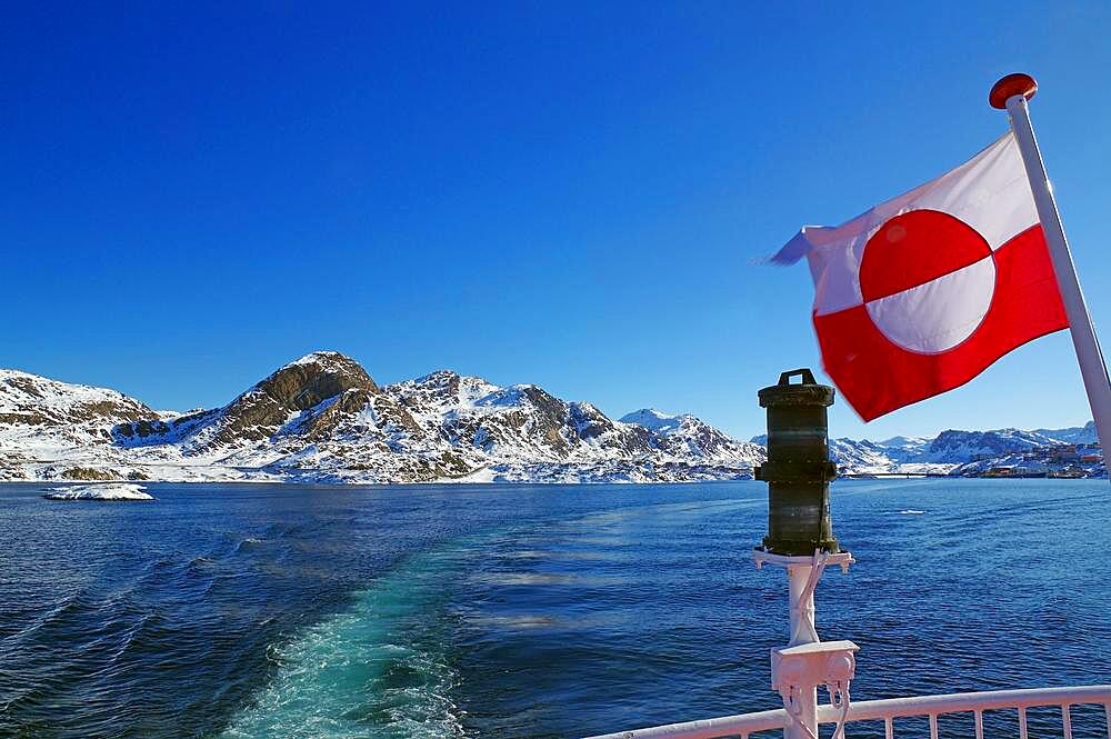 Greenland national flag and coastal landscape with snow, winter, Greenland, Denmark, North America