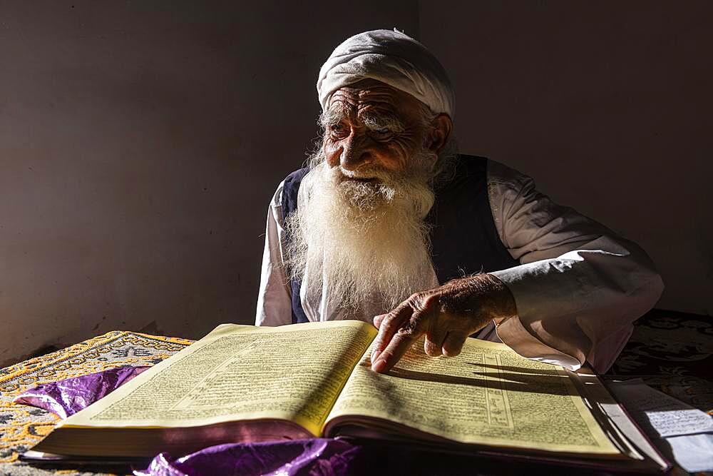 Sufi priest studying the holy Quran in the Shrine of Mawlana Abdur Rahman Jami, Herat's greatest 15th century poet, Herat, Afghanistan, Asia