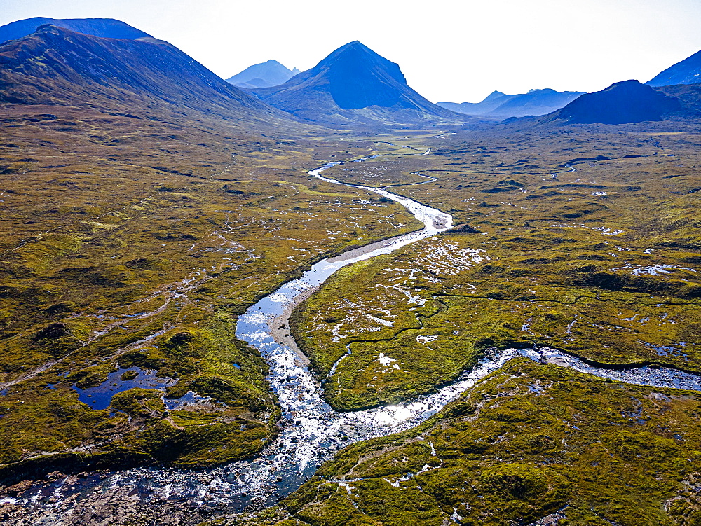 Aerial of a river sneaking through the moor of the Black Cuillin ridge, Isle of Skye, Scotland, UK