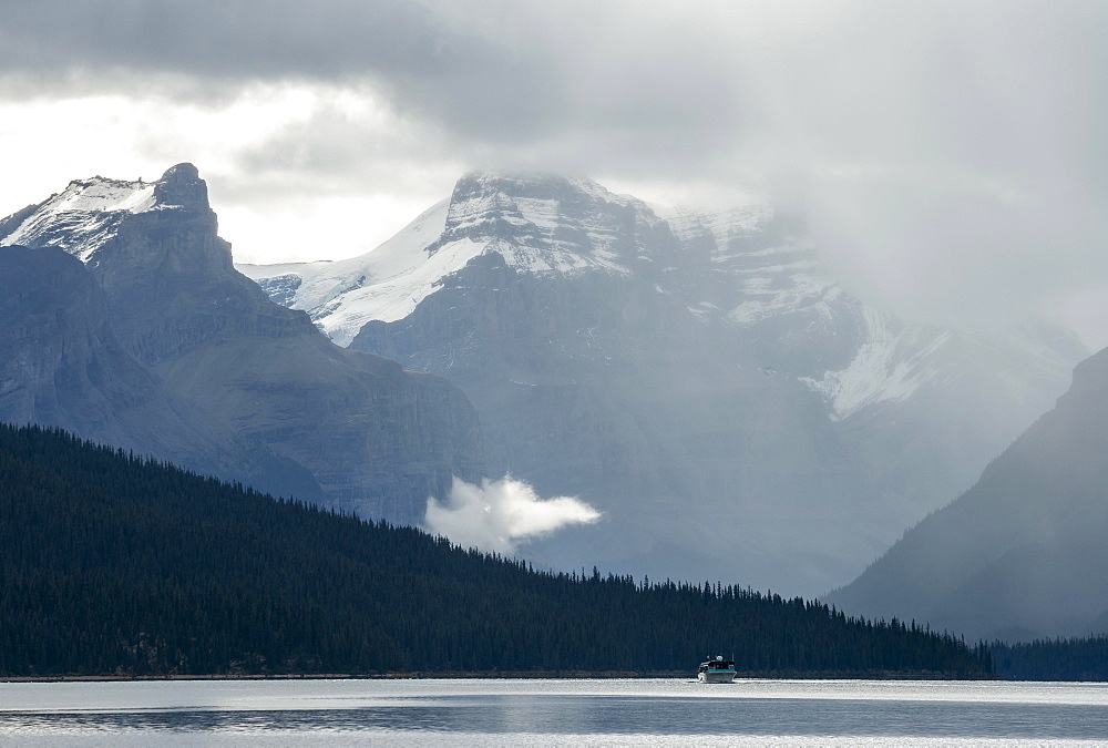 Boat on Maligne Lake, behind it mountain range Queen Elizabeth Ranges with Samson Peak, cloudy sky, Jasper National Park, Rocky Mountains, Alberta, Canada, North America