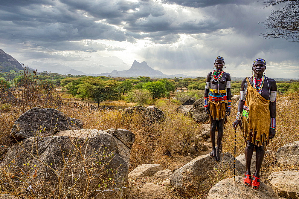 Traditional dressed young girls from the Laarim tribe standing on a rock, Boya hills, Eastern Equatoria, South Sudan, Africa