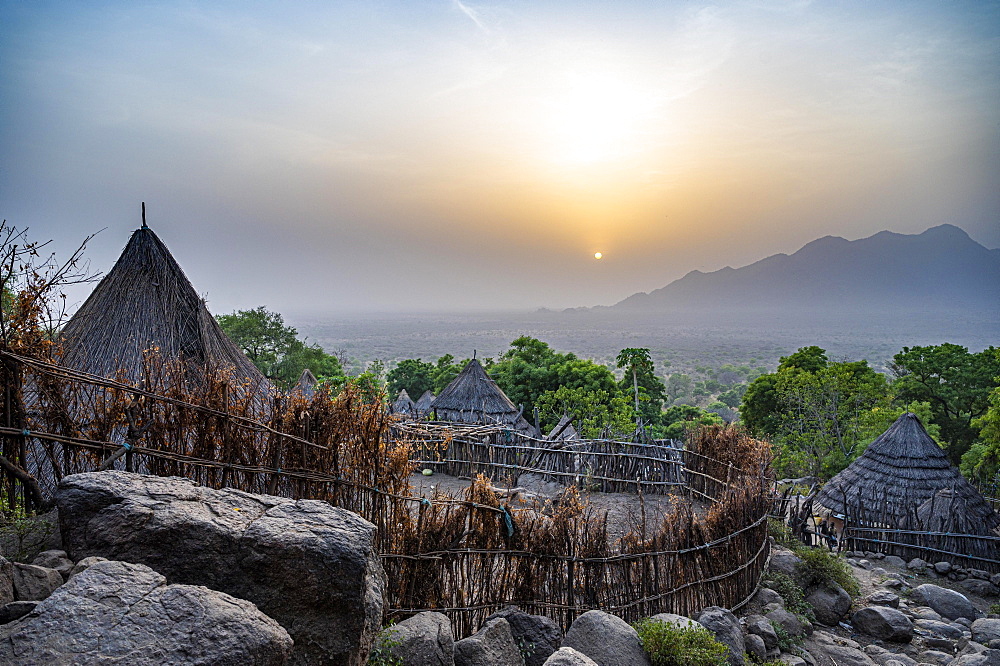 Sunset over traditional huts of the Otuho or Lutoko tribe in the village in the Imatong mountains, Eastern Equatoria, South Sudan, Africa