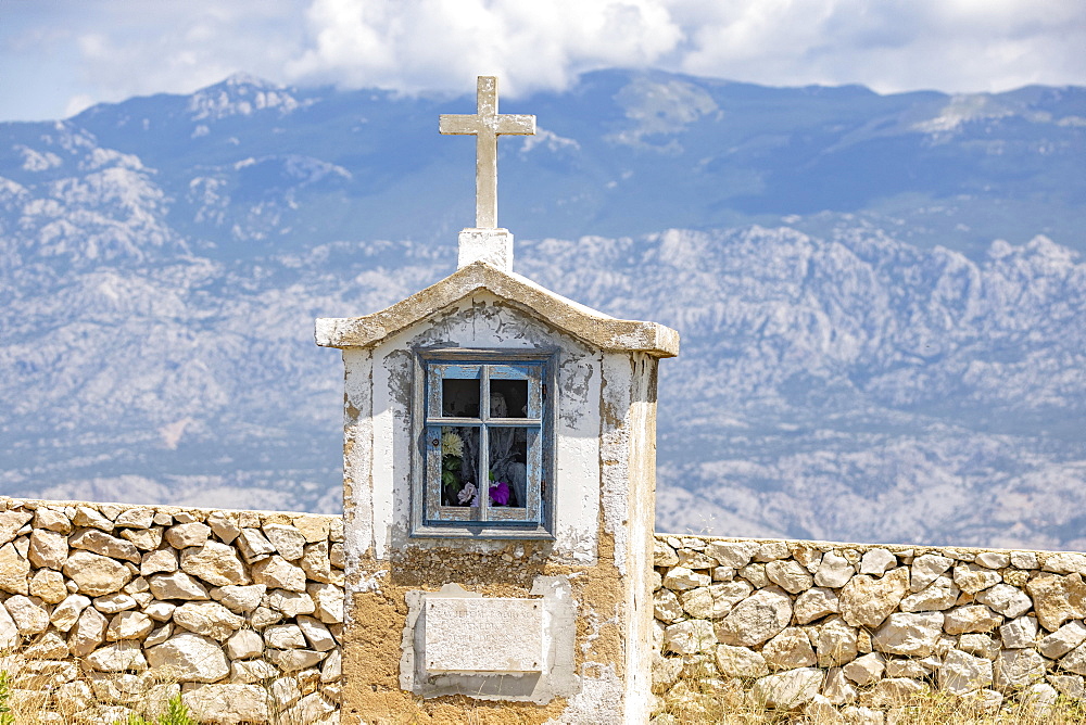 Wayside shrine in front of mountains on the mainland, Pag Island, Croatia, Europe