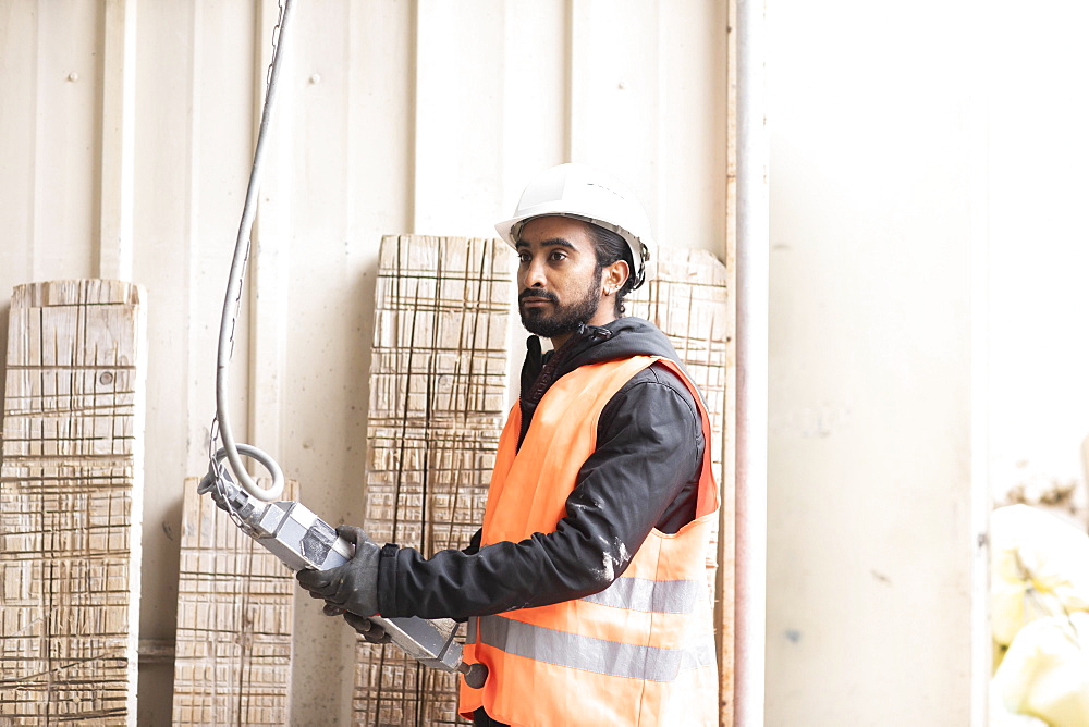 Technician with beard and helmet works in a workshop, Freiburg, Baden-Wuerttemberg, Germany, Europe