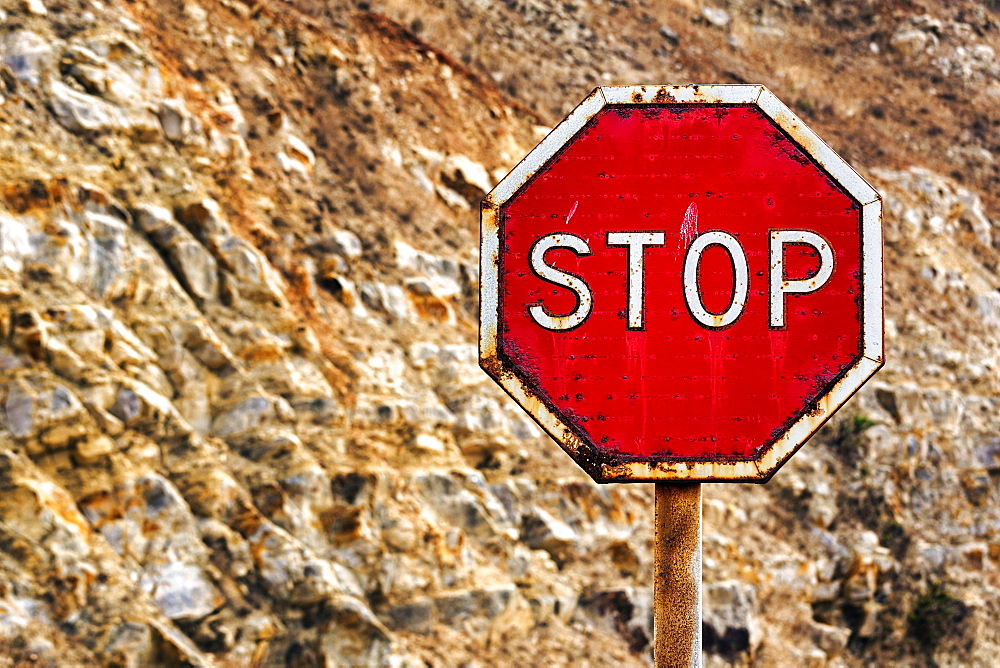 Old stop sign, rusted, in front of a rock face, Algarve, Portugal, Europe