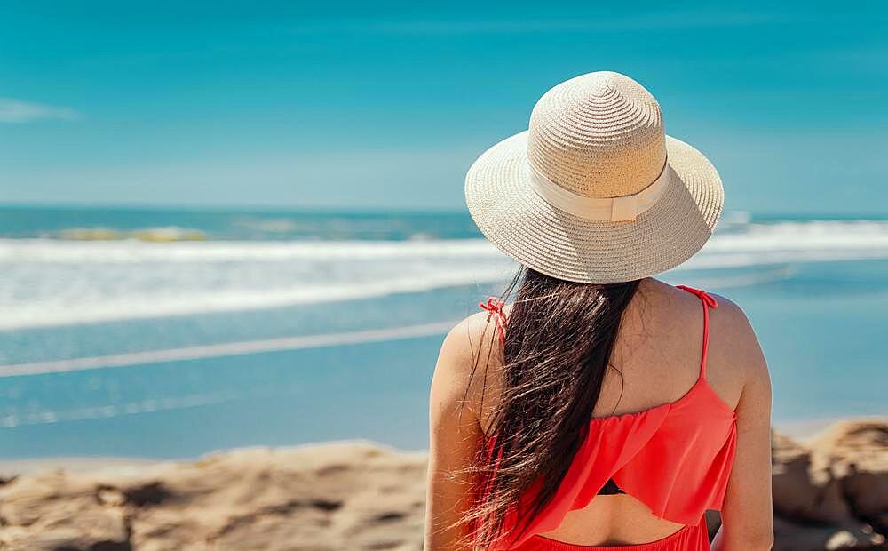 Woman in hat from back to the sea, girl in hat looking to the sea, vacation concept, rear view of a girl watching the sea, Nicaragua, Central America