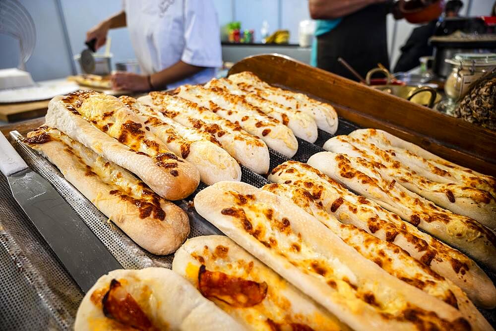 Long pizza bread with cheese and chourico sausage sold at Santa Iria Fair in Faro, Algarve, Portugal, Europe