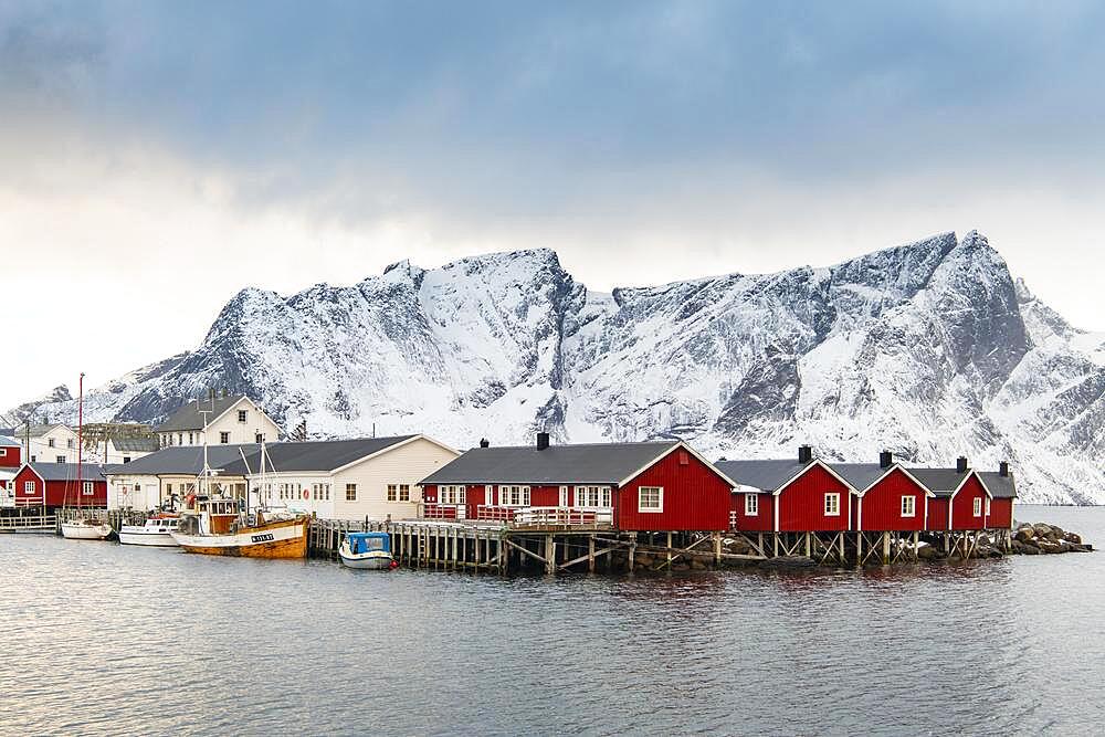 Red boathouses in winter harbour, Scandinavian boathouse, mountains, snow, fjord, sea, Hamnoy, Nordland, Lofoten, Norway, Europe