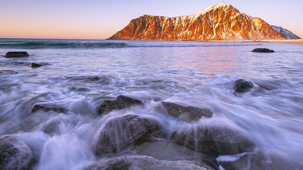 Winter Scandinavian landscape at sunrise, sea, waves, mountains, snow, fjord, Norway in winter, Flakstad, Nordland, Lofoten, Norway, Europe