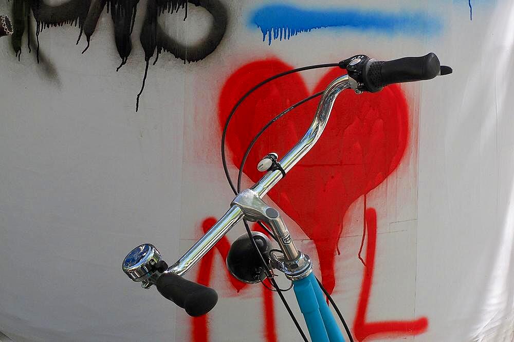 Handlebars from bicycle in front of wall with red heart symbol, bicycle handlebars in front of painted heart, heart shape, symbol of love, sign of love, love symbol, proof of love, heart symbol, organ heart, kindness, affection, inflamed, in love, crush, colour red, heart emoji, Spain, Europe