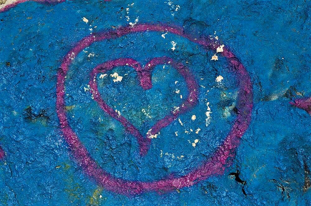 Painted heart as @ symbol painted on blue wall, pink heart in circle on blue wall, heart shape, symbol of love, sign of love, love symbol, proof of love, heart symbol, organ heart, kindness, affection, inflamed, in love, crush, colour red, heart emoji