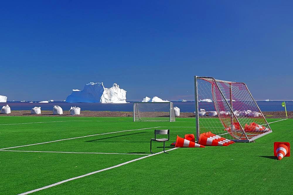 Football ball with goals in front of icebergs, artificial turf, Disko Island, Disko Bay, Qeqertarsuaq, Arctic, Greenland, Denmark, North America